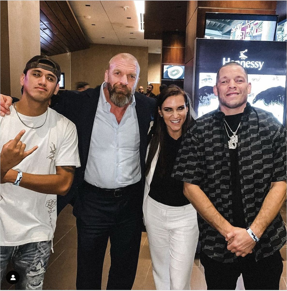 Nate Diaz (Right) with Triple H and Stephanie McMahon (Middle)