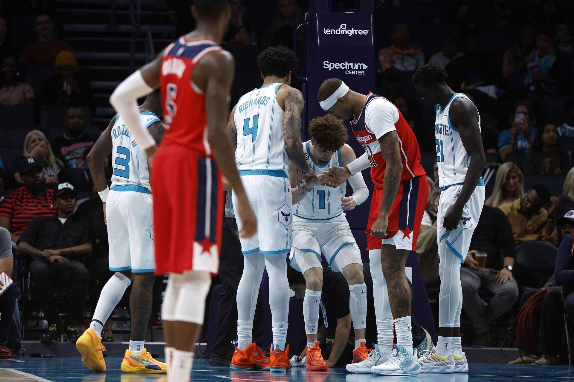 Charlotte Hornets guard LaMelo Ball is being helped up after injuring his ankle on Monday.