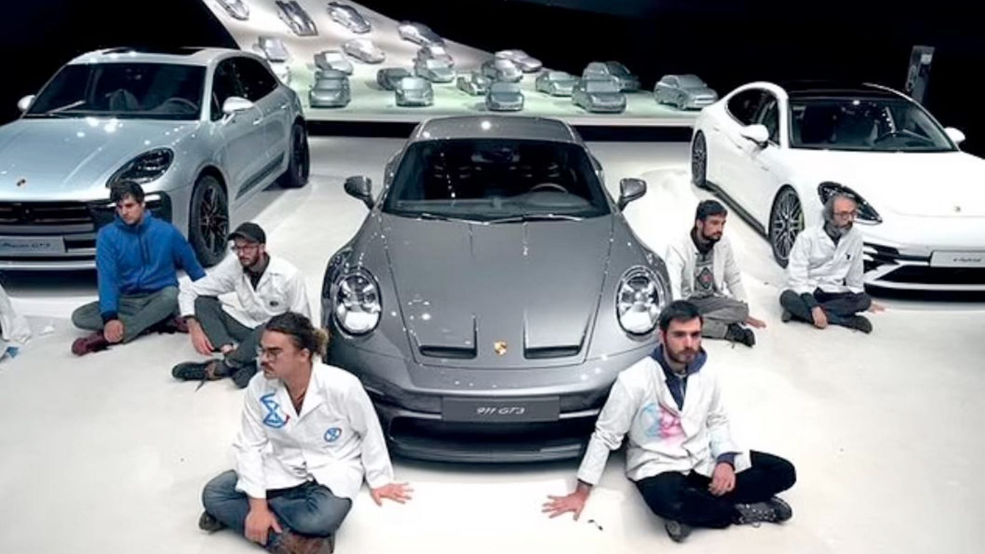 Protestors glue themselves to a Porsche showroom floor (image via Twitter)