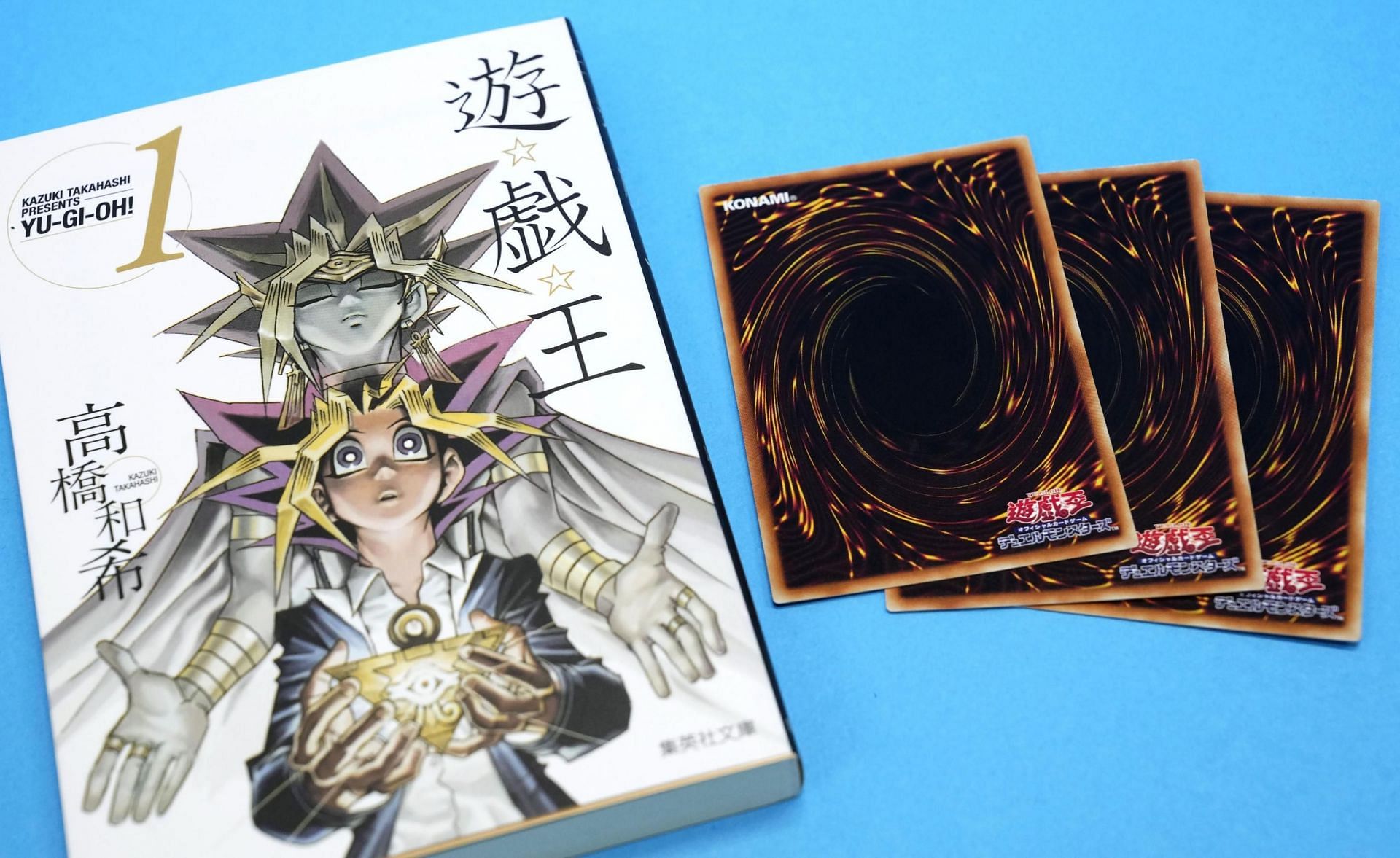 Yu-Gi-Oh manga volume 1 and cards (Image via Viz Media)