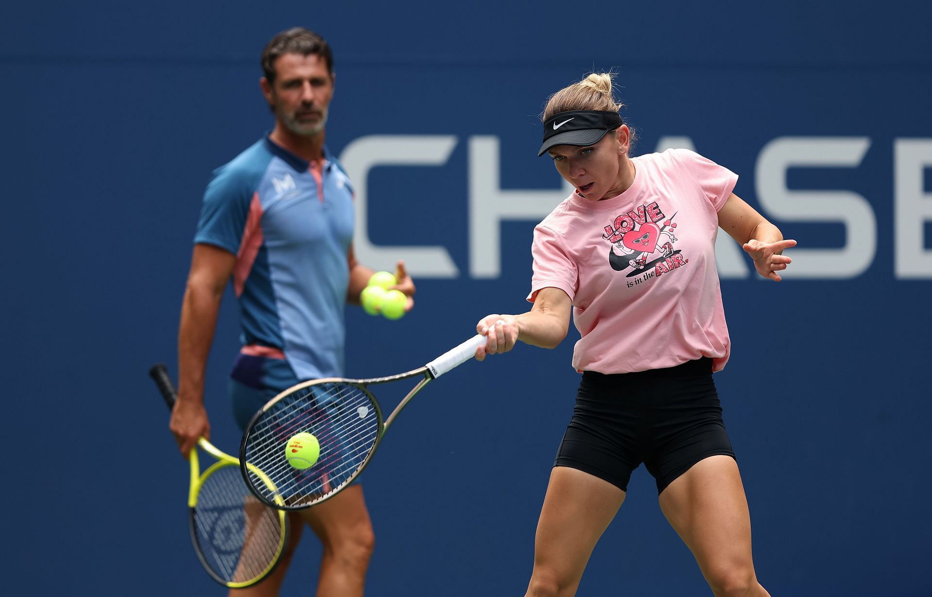 Simona Halep (right) practices for the 2022 US Open as coach Patrick Mouratoglou looks on.