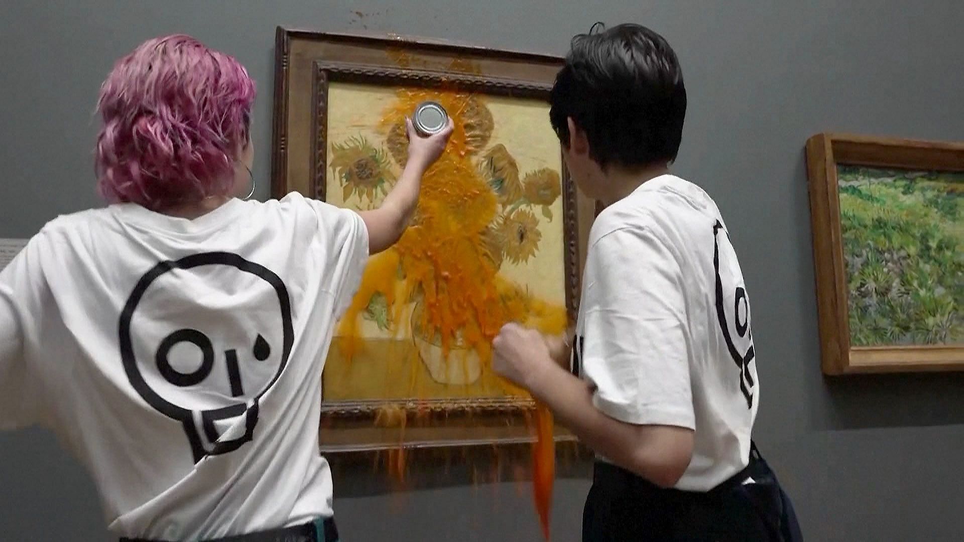 Two activist deface a Van Gogh painting (image via NBC news)