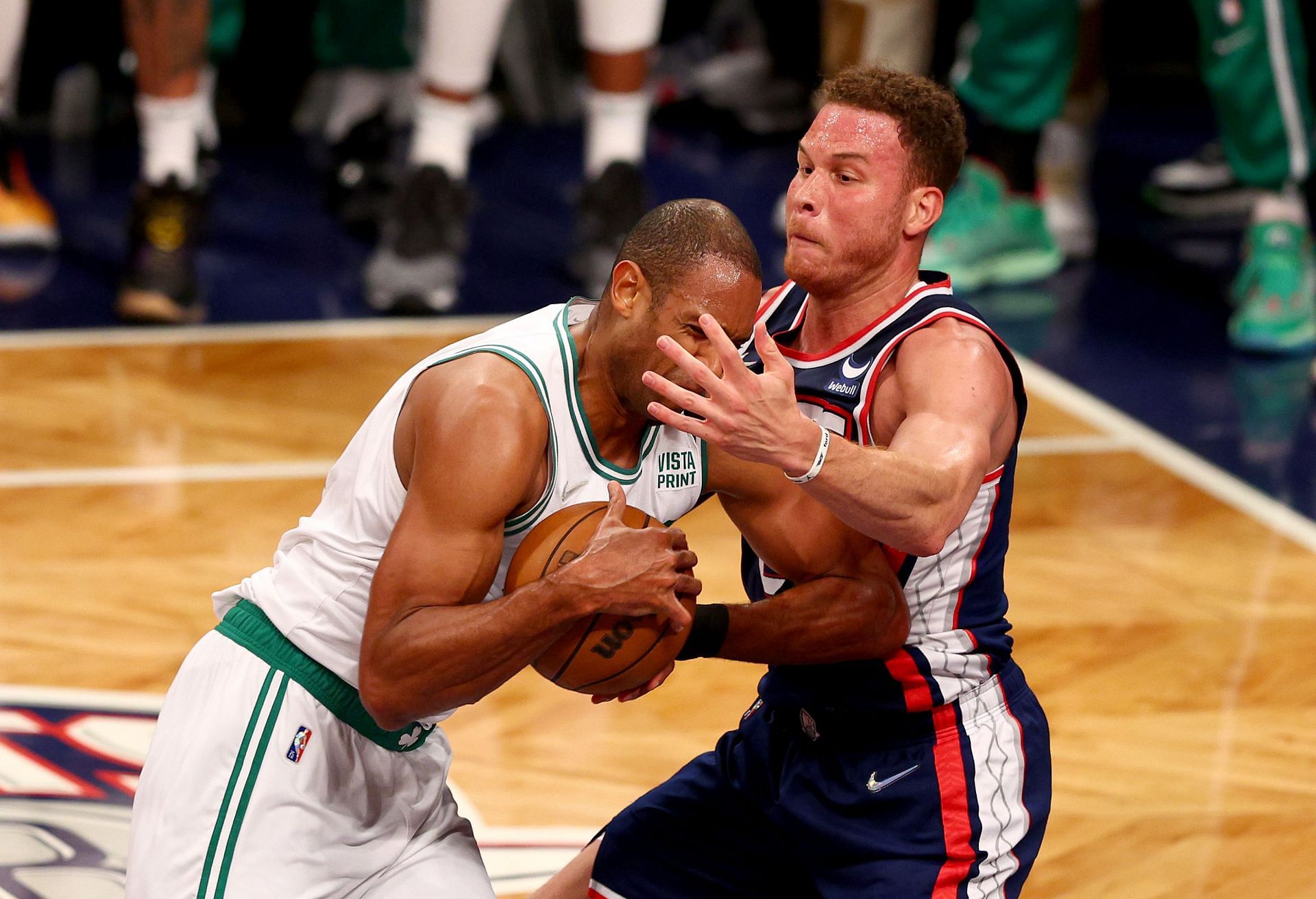 Al Horford of the Boston Celtics (left) tussles for the basketball with Blake Griffin