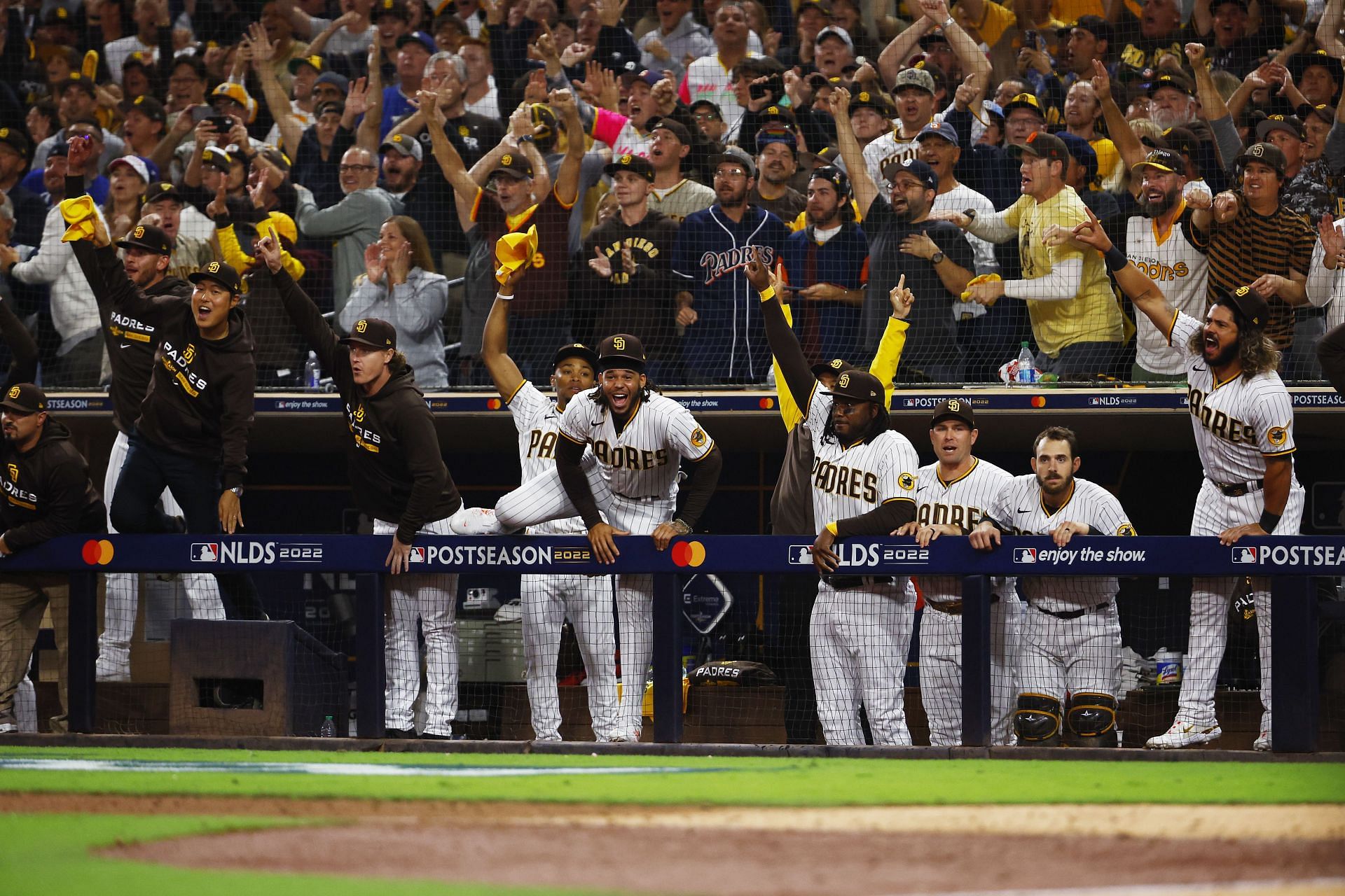 The San Diego Padres dugout celebrates against the Los Angeles Dodgers at PETCO Park