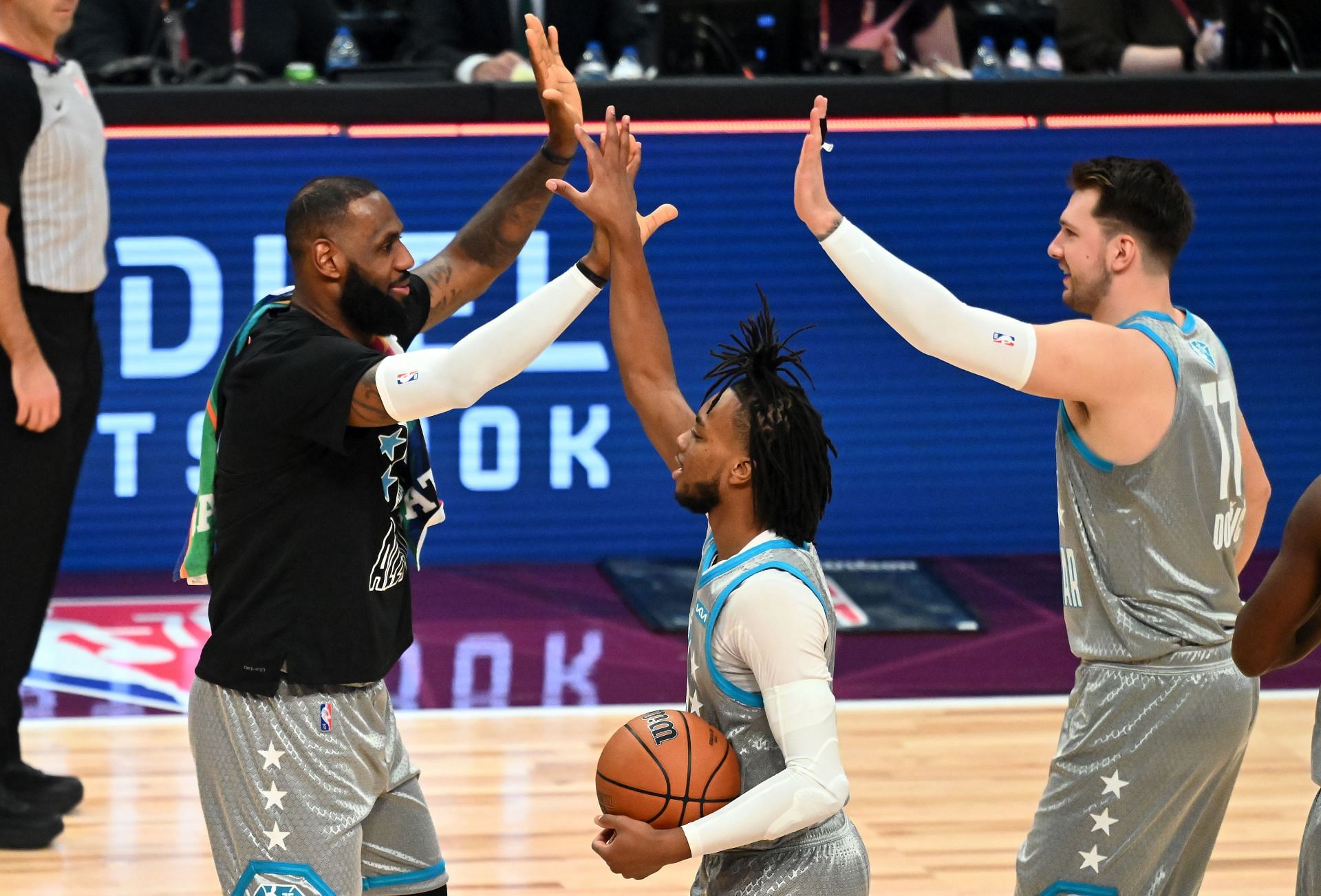 LeBron James of Team LeBron reacts with teammates Darius Garland and Luka Doncic