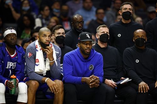 Kawhi Leonard watches a game from the bench in street clothes