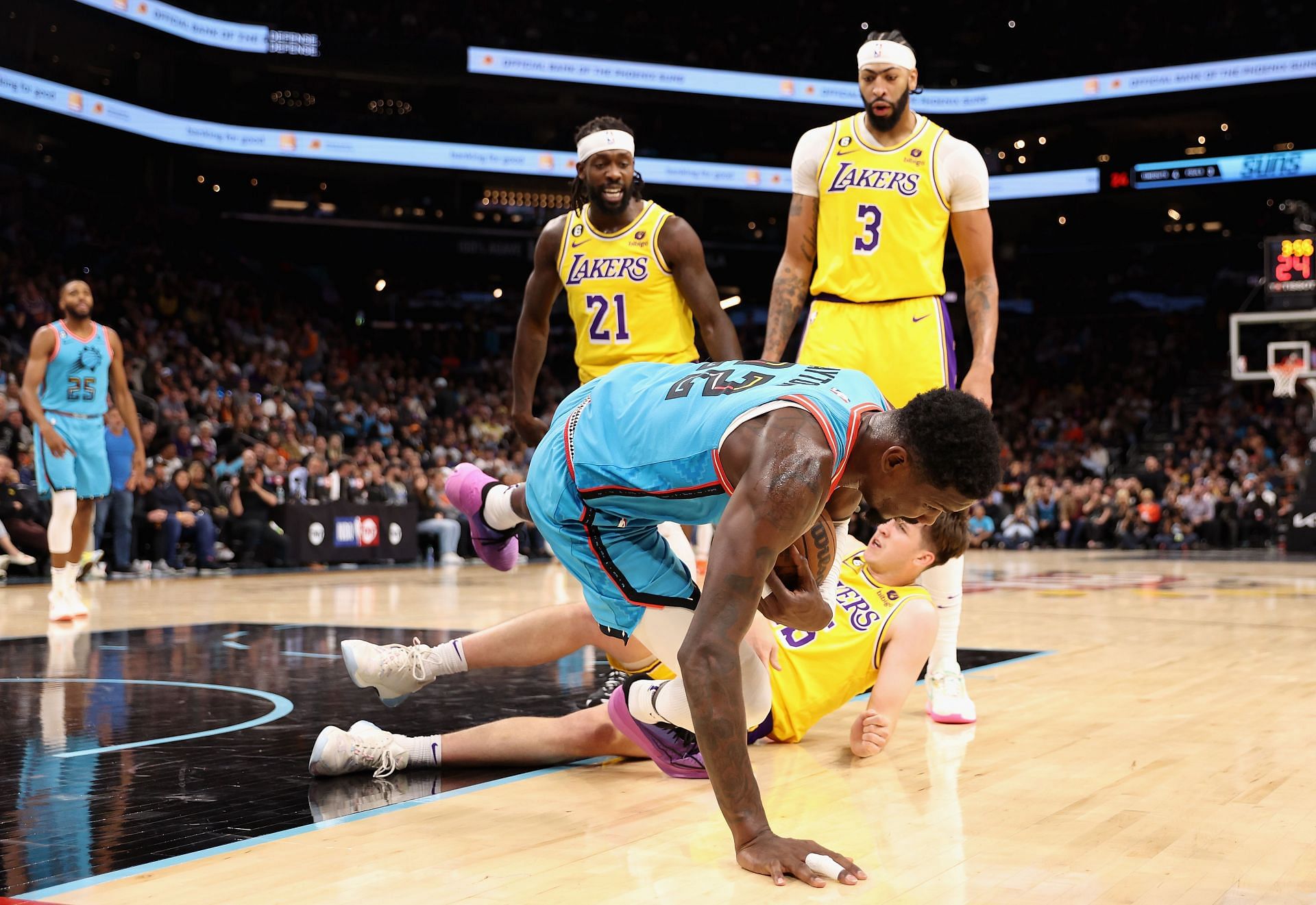 Deandre Ayton  falls over Austin Reaves of the LA Lakers after being pushed by Patrick Beverley