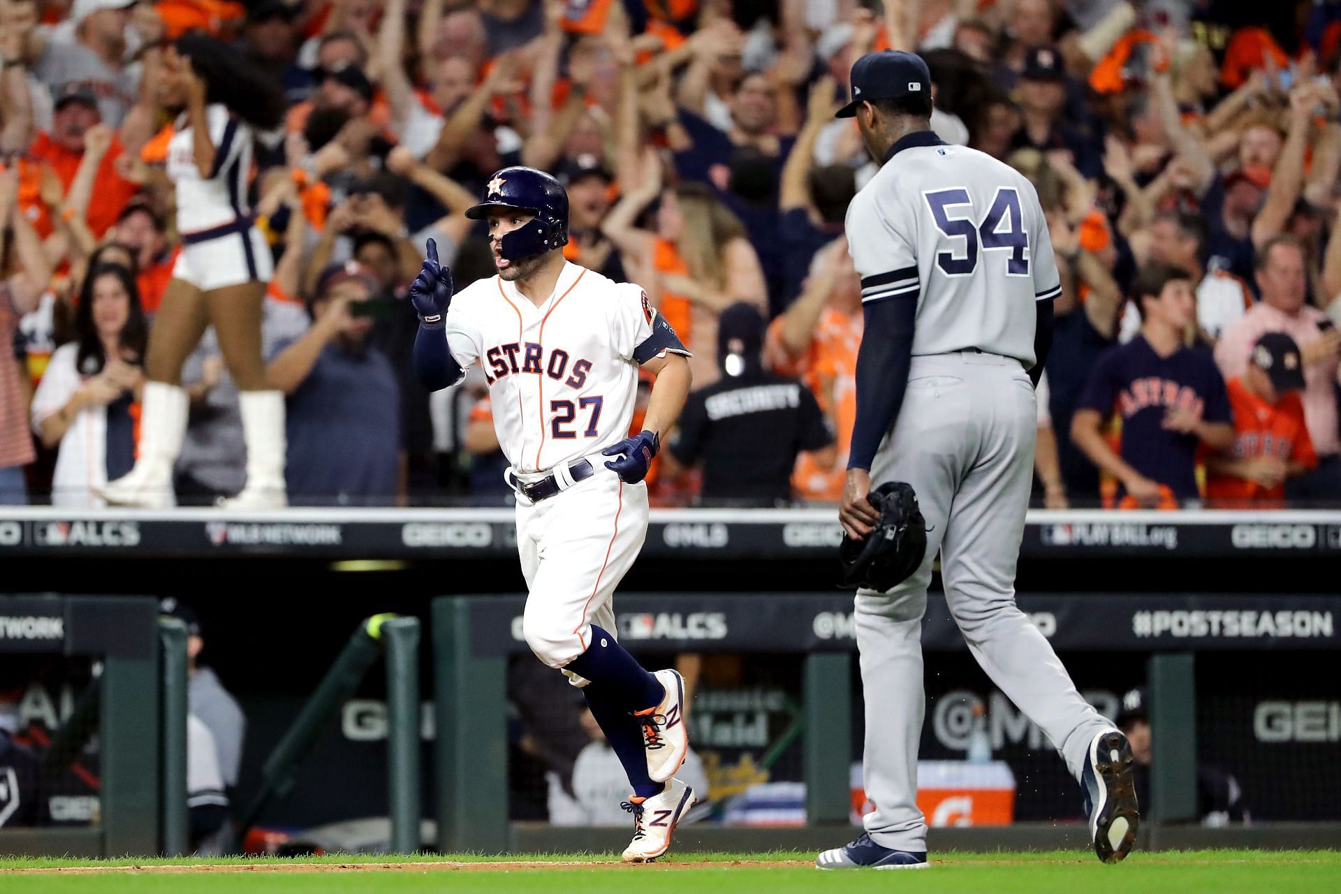 Jose Altuve #27 of the Houston Astros comes home to score following his ninth inning walk-off two-run home run as Aroldis Chapman #54 of the New York Yankees walks off the field in 2017