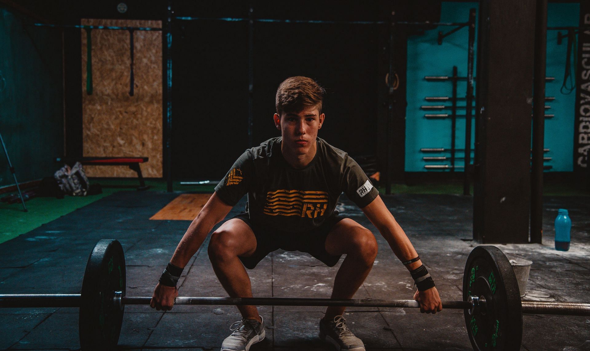 Squat exercises may focus mostly on your legs, but they also train your abs as well as obliques. (Image via Unsplash/ Luis Vidal)