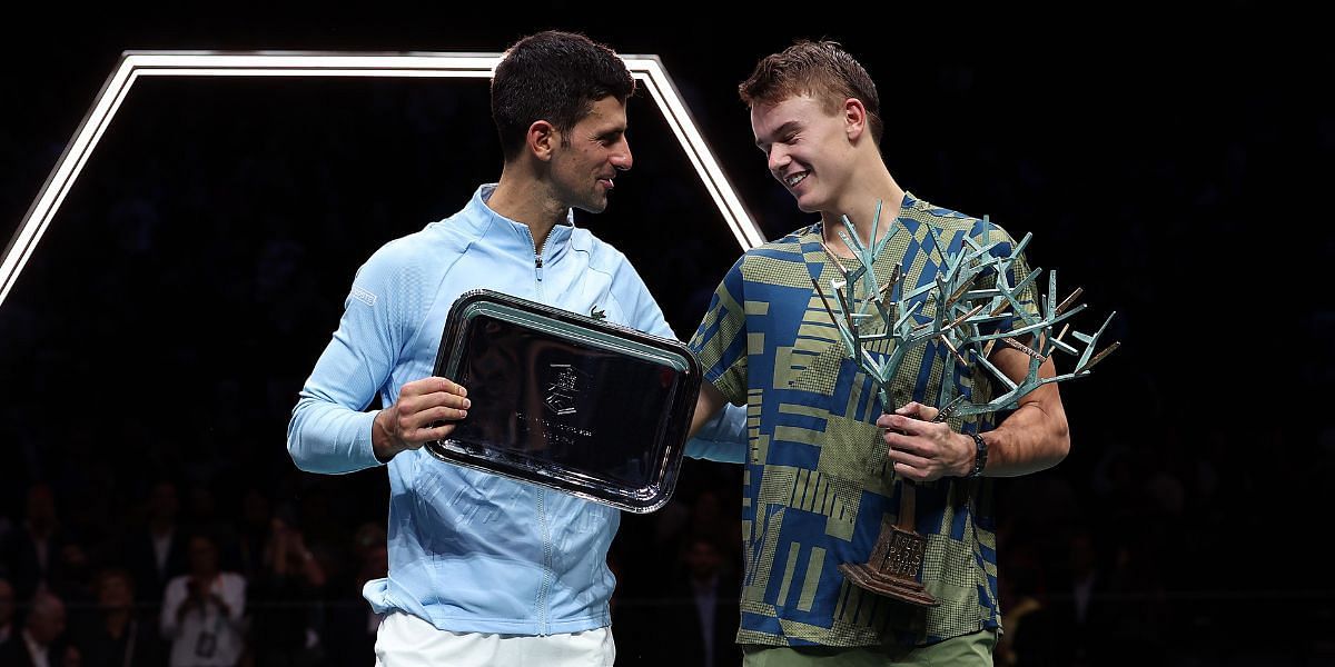 Holger Rune flaunts his 2022 Paris Masters title [R] with runner-up Novak Djokovic [L]