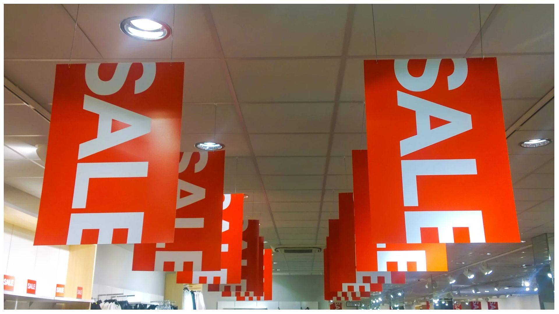 sale flyers hang in a store during Black Friday (Image via GettyImages)