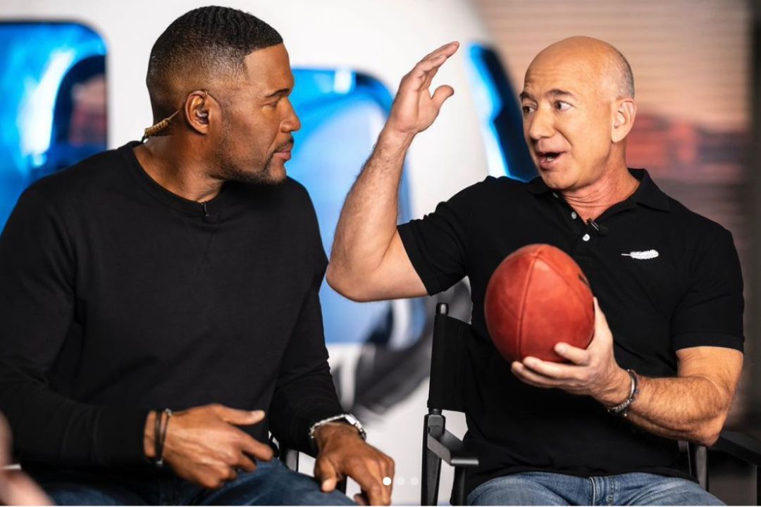 Jeff Bezos (holding football) w/ NFL HOF DE Michael Strahan. Source: Jeff Bezos IG