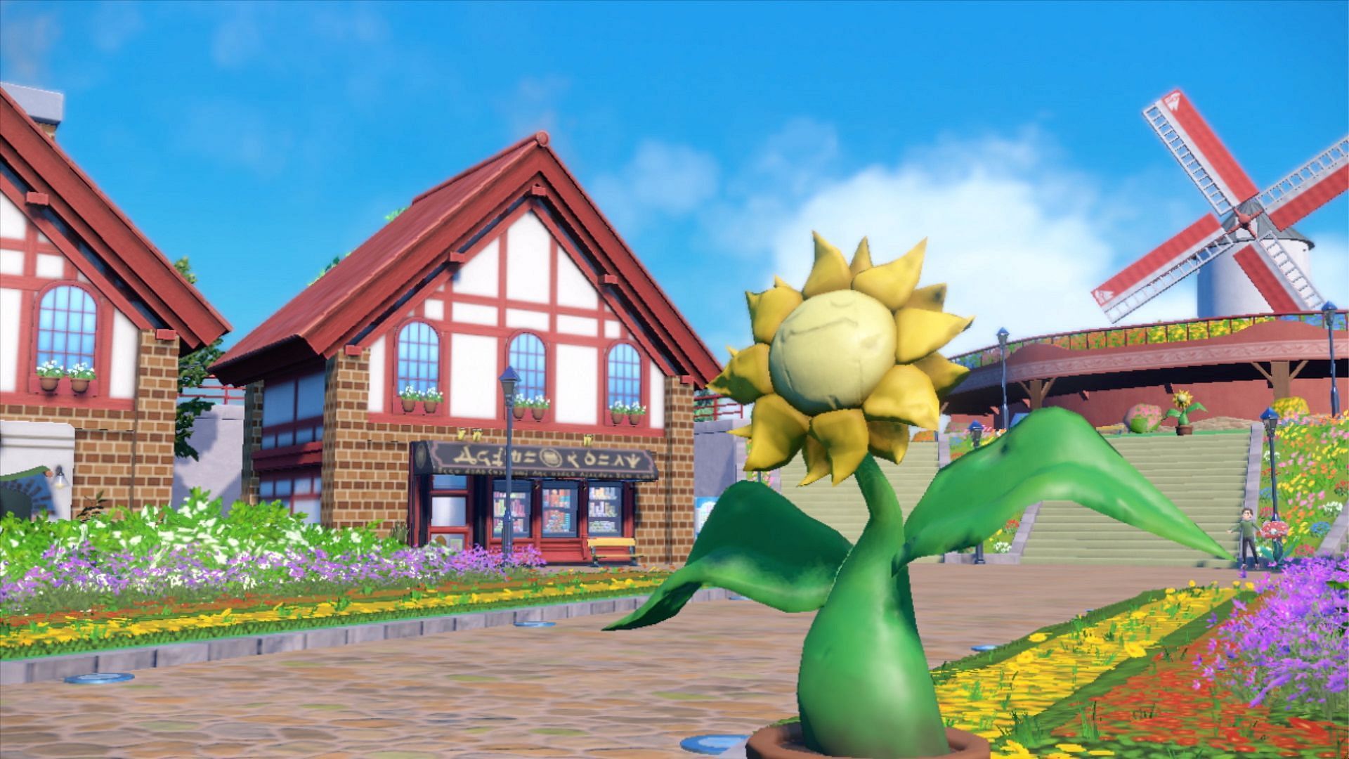 A screenshot from Pokemon Scarlet and Violet showing the town of Artazon, its various statues, and its gym arena (Image via The Pokemon Company)