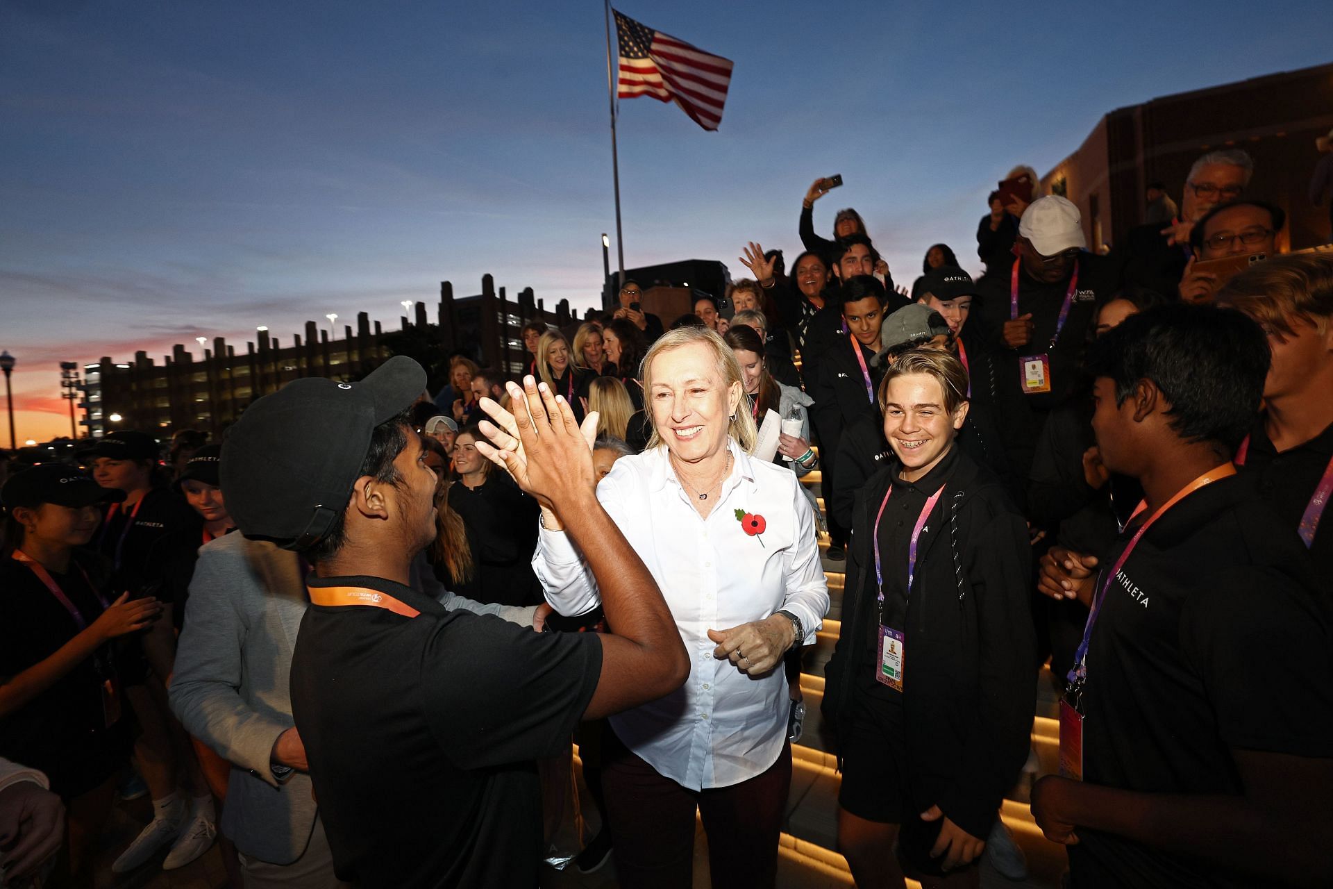 Martina Navratilova (C) high-fives a ball kid at the 2022 WTA Finals - Day 6