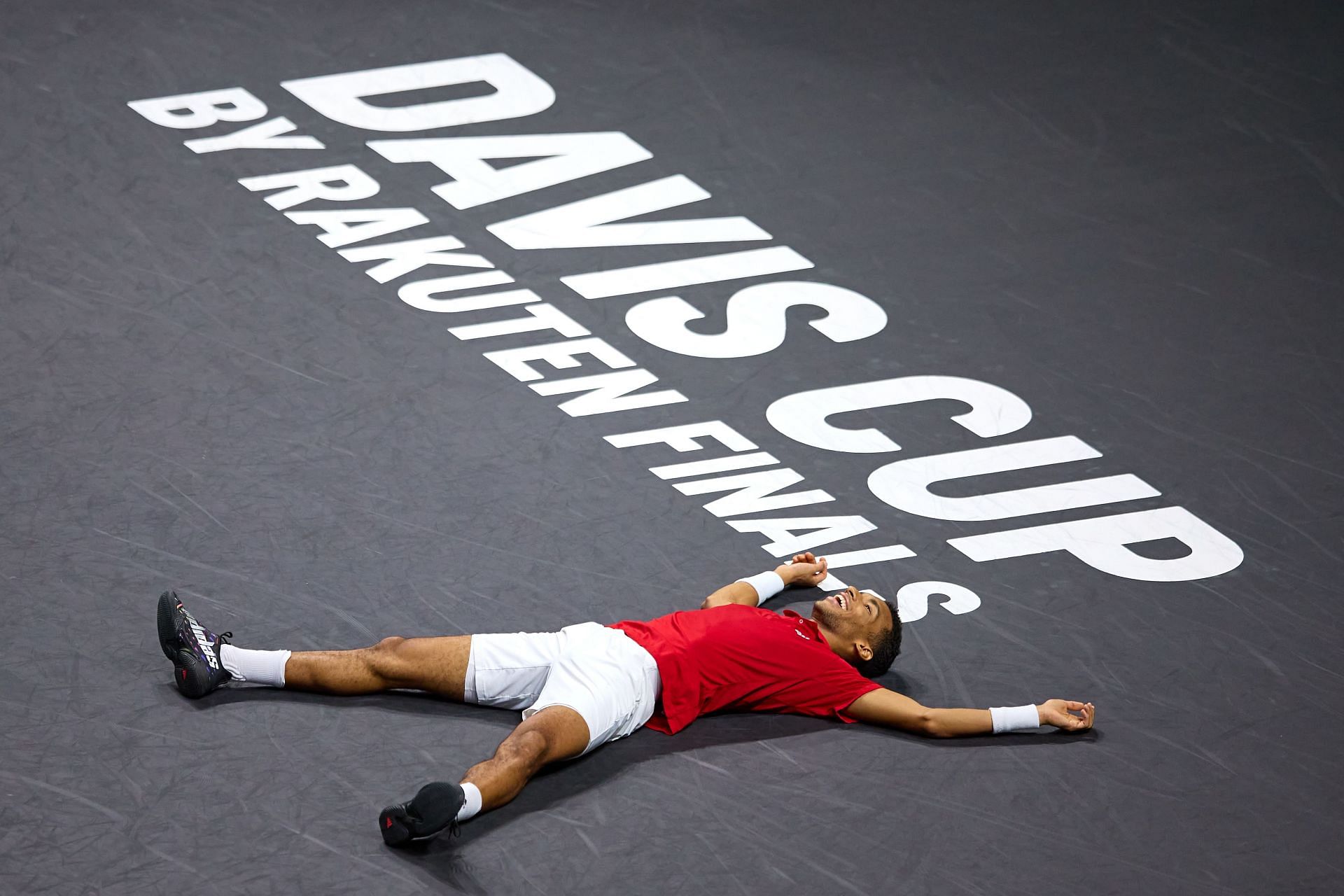 Felix Auger-Aliassime sprawls on the court as he claims the victory for Canada in the Davis Cup.