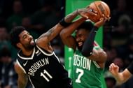 Kyrie Irving of the Brooklyn Nets goes up against Jaylen Brown of the Boston Celtics