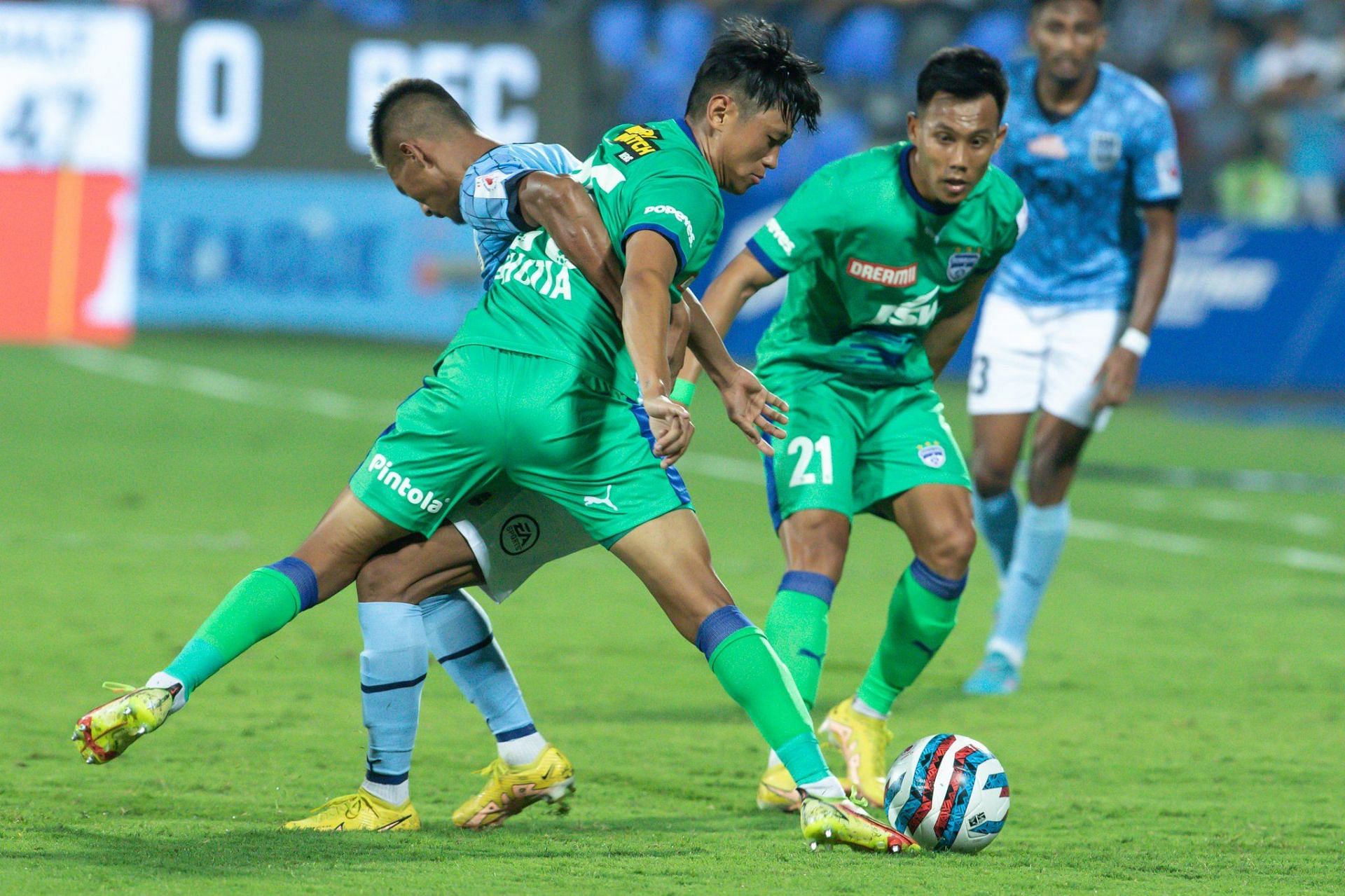 Bengaluru FC and Mumbai City FC players tussling for the ball.
