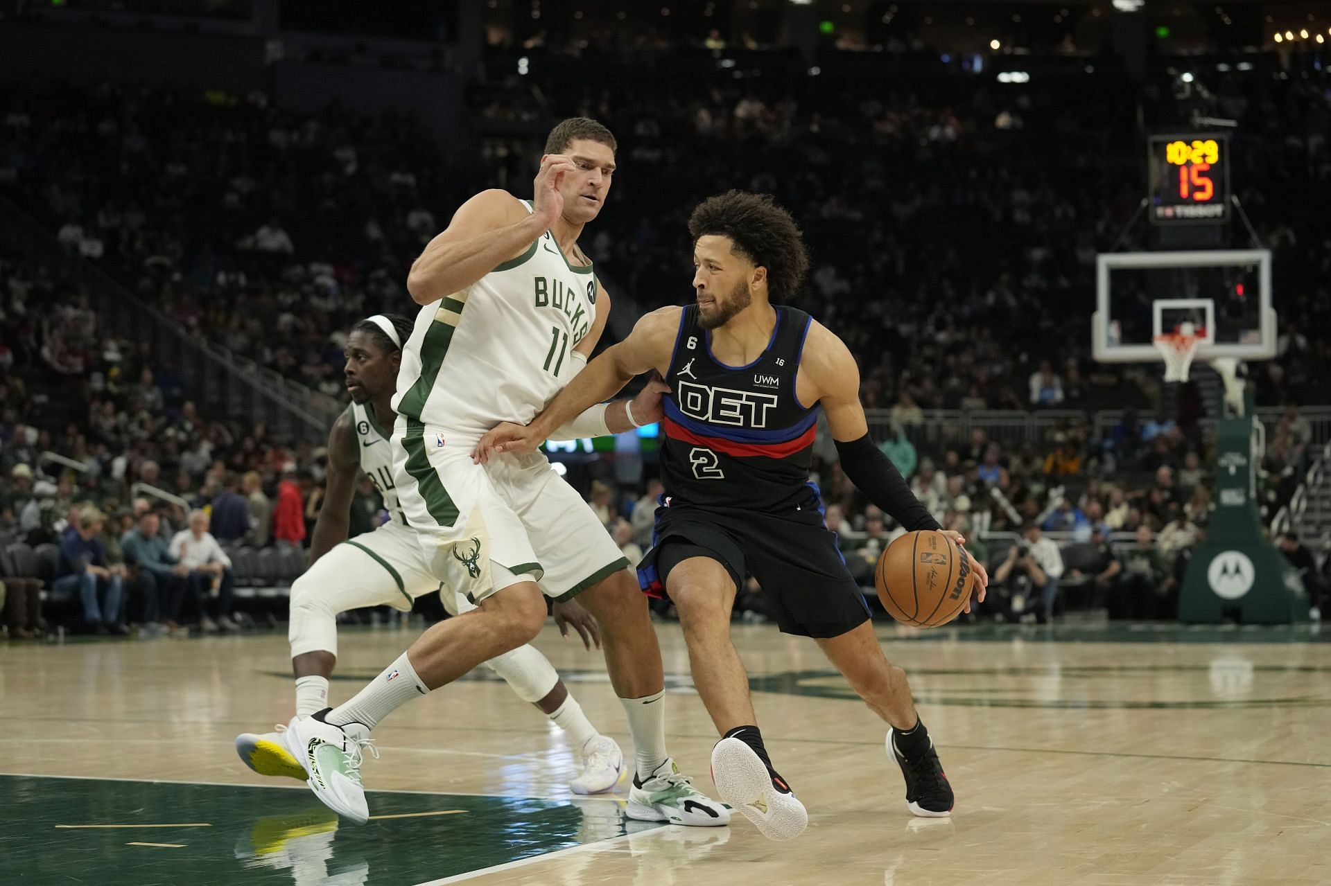 Cade Cunningham of the Detroit Pistons drives against Brook Lopez of the Milwaukee Bucks
