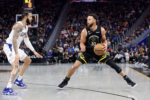 Stephen Curry of the Golden State Warriors is guarded by Amir Coffey of the LA Clippers