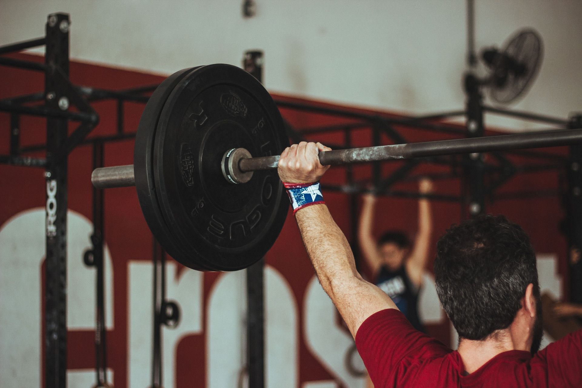 The overhead press can help you build muscle mass and boost your athletic performance! (Image via unsplash/Victor Freitas)