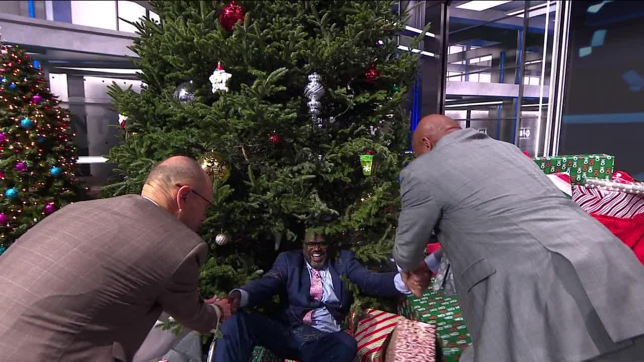 Shaquille O&#039;Neal getting helped up after being pushed into a Christmas tree by co-host Kenny Smith
