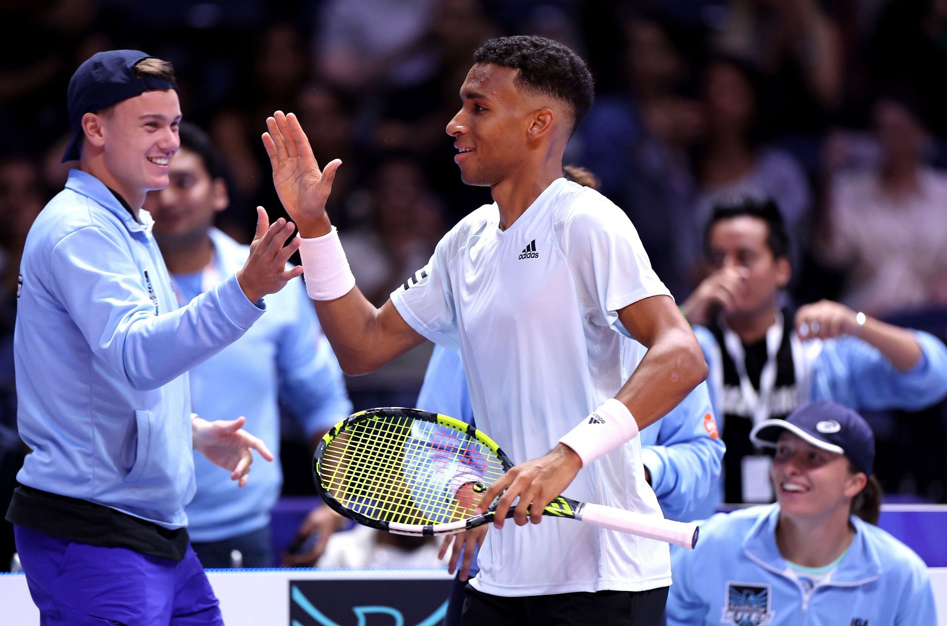 Felix Auger-Aliassime celebrates with Iga Swiatek and other teammates at World Tennis League.