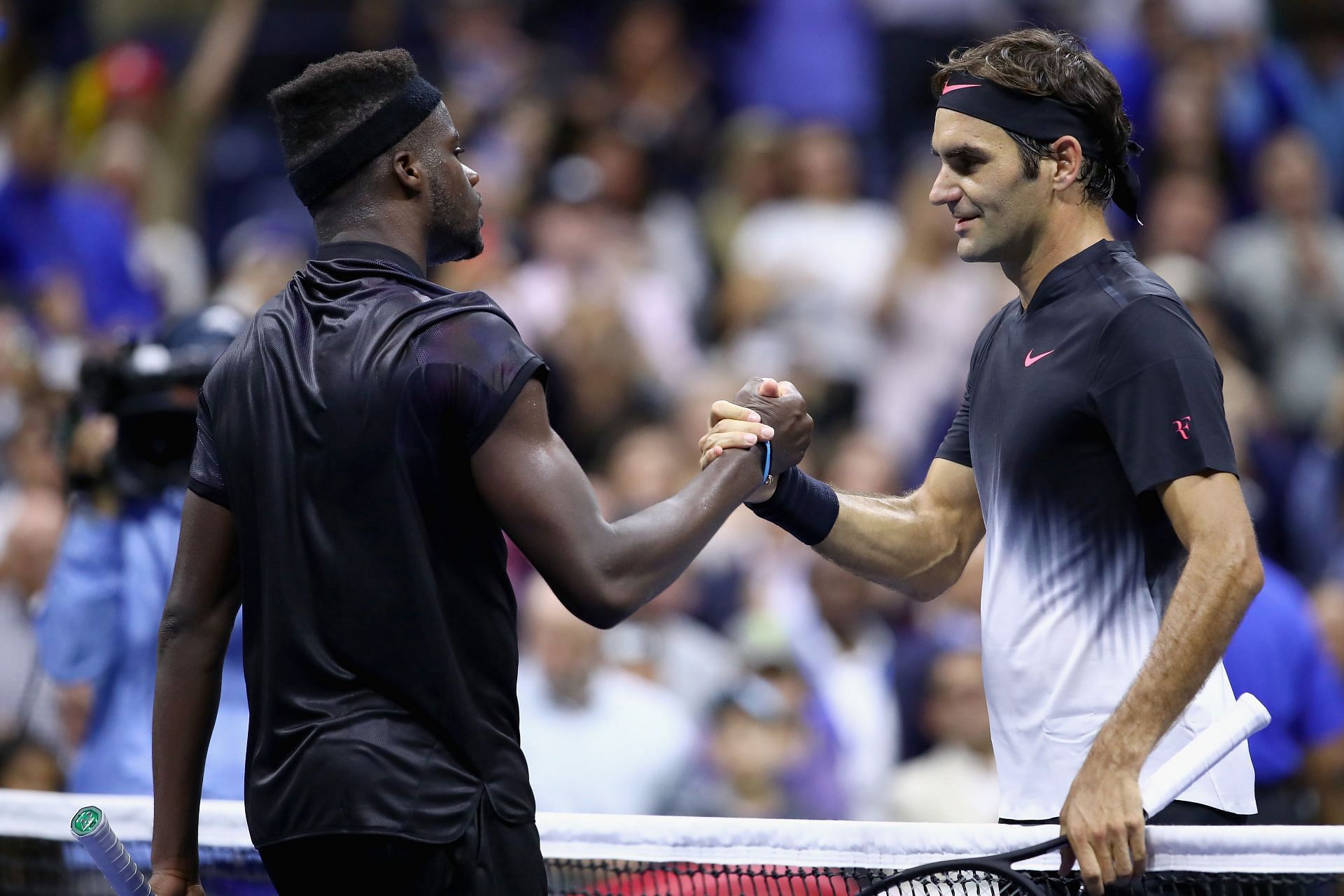 Frances Tiafoe (L) and Roger Federer