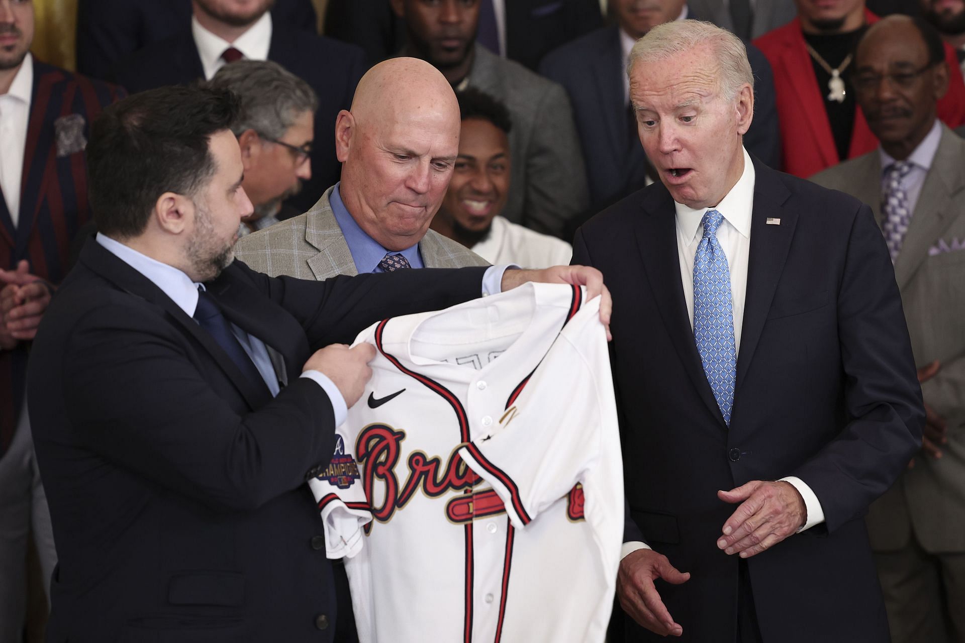 U.S. President Joe Biden receives an Atlanta Braves jersey from Braves Manager Brian Snitker and Braves General Manager Alex Anthopoulos.