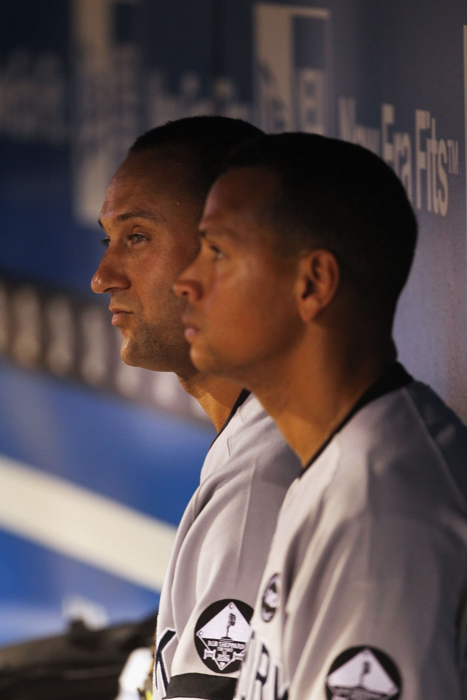Derek Jeter #2 and Alex Rodriguez #13 of the New York Yankees watch from the dugout during the game against the Kansas City Royals on August 13, 2010 at Kauffman Stadium in Kansas City, Missouri.