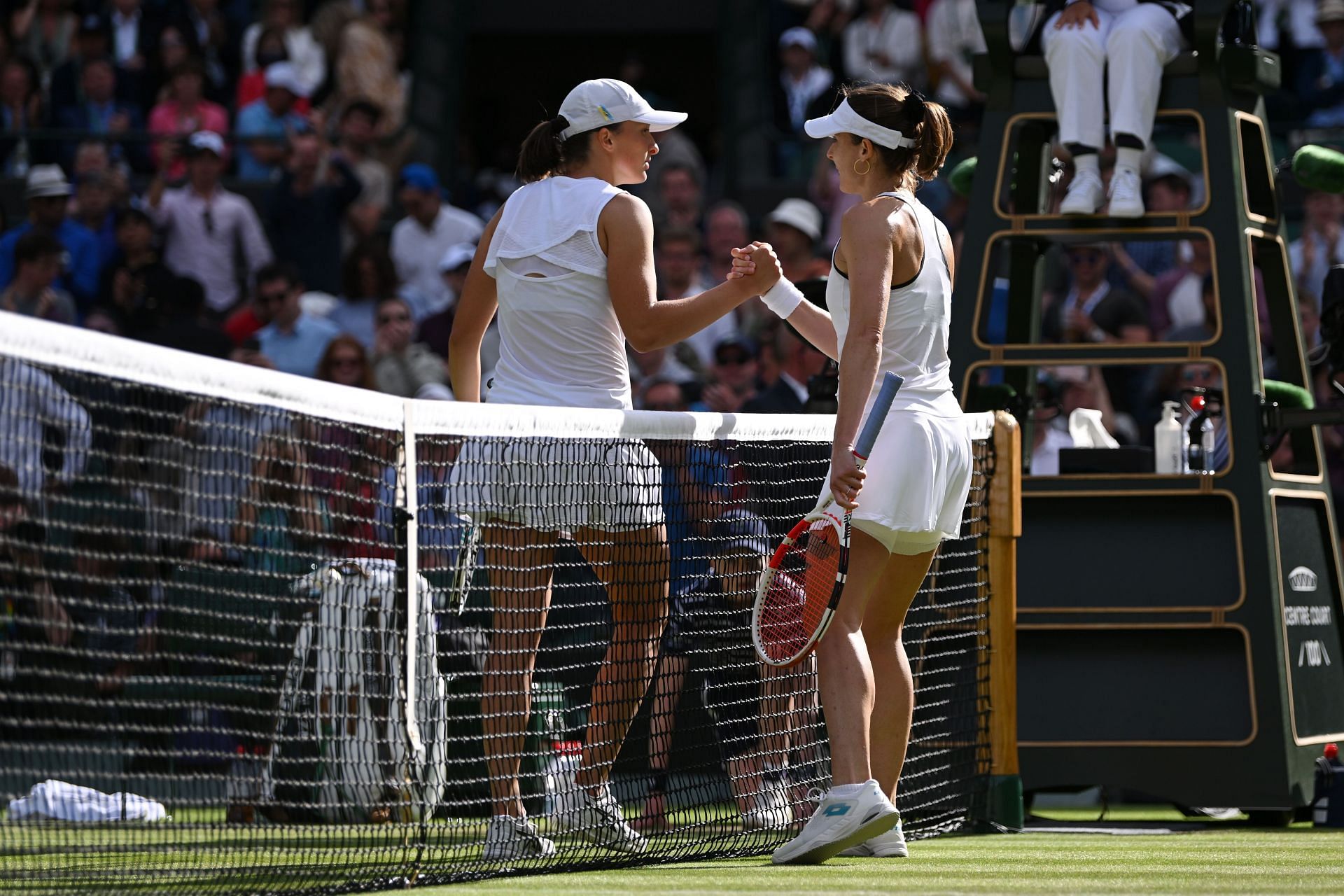 Alize Cornet and Iga Swiatek shake hands following their third-round match at Wimbledon