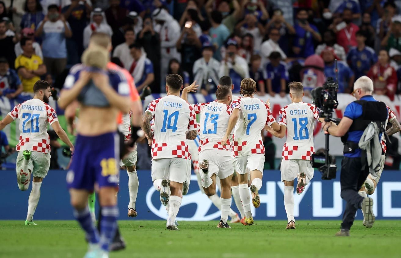 हार के बाद निराश जापानी खिलाड़ी और उनके पीछे खुशी से भागते दिख रहे क्रोएशियाई प्लेयर्स।