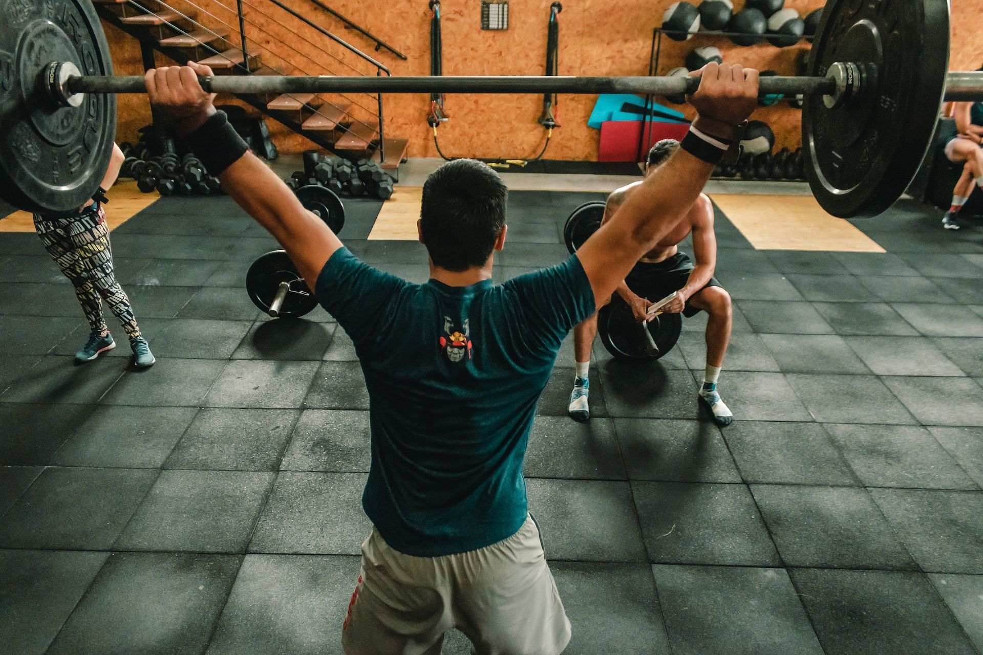 Barbell overhead movements are a great back strengthening move. (Photo via Pexels/Victor Freitas)
