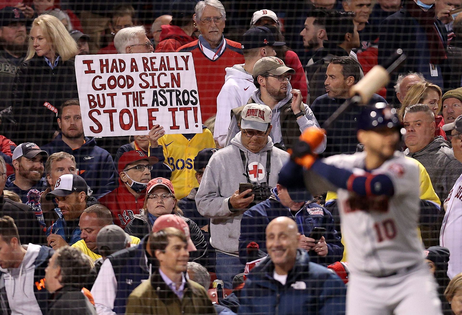 A sign referring to the Houston Astros cheating is held by a fan at Fenway Park
