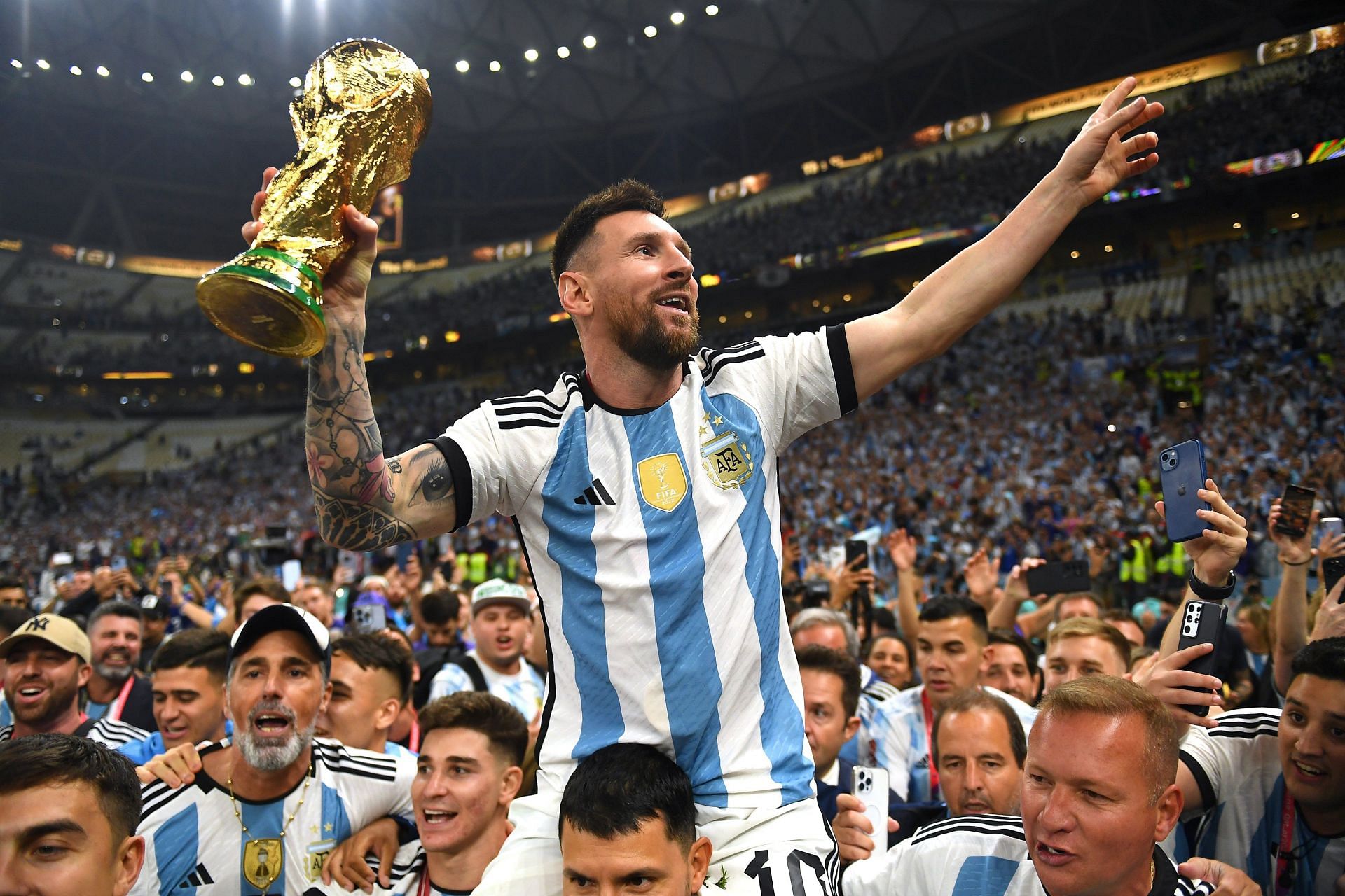 फुटबॉल विश्व कप ट्रॉफी को थामे अर्जेंटीना के स्टार खिलाड़ी लायोनल मेसी।