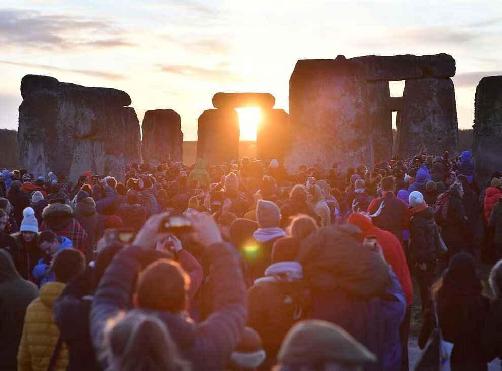 People gathered to watch the sunrise at Stonehenge (Image via PA/ Ben Birchall)