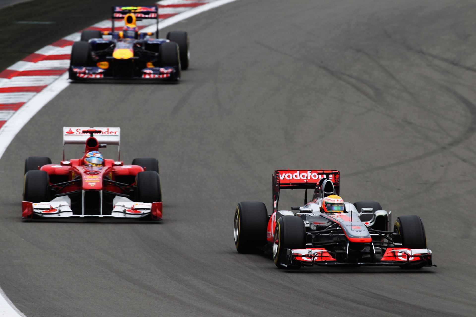 Race winner Lewis Hamilton of Great Britain and McLaren leads from second-placed Fernando Alonso of Spain and Ferrari and third-placed Mark Webber of Australia and Red Bull Racing. (Photo by Mark Thompson/Getty Images)