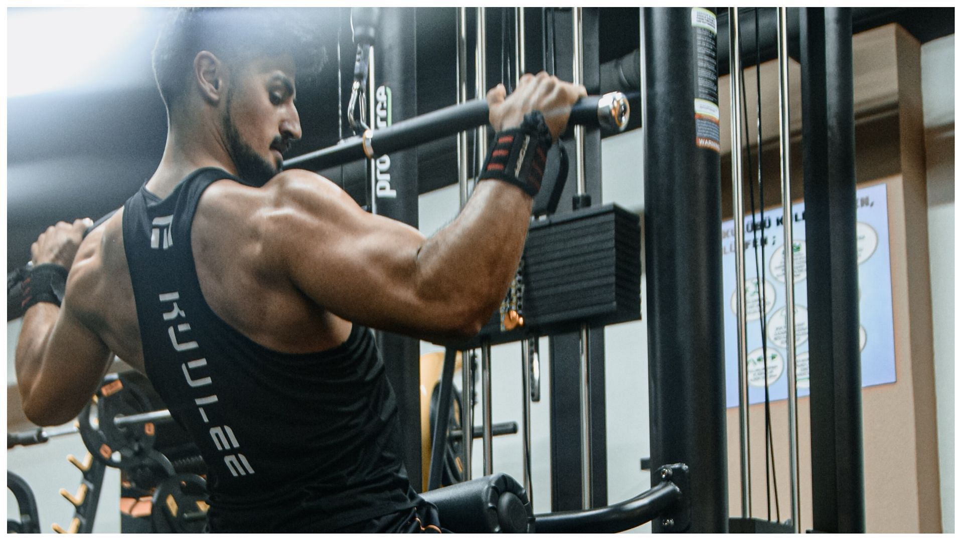 Perform wide-grip lat pulldowns to develop wide lats (Image via Pexels)