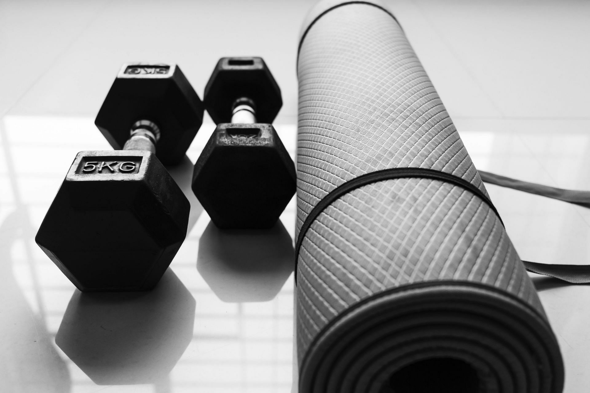 An image of a dumbbell next to a yoga mat.
