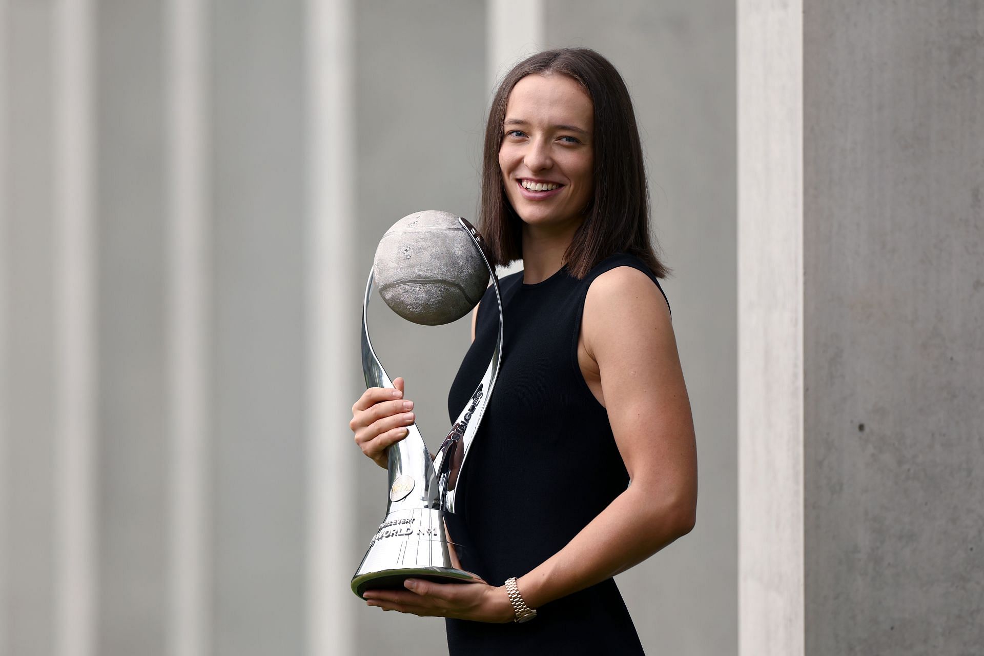 Iga Swiatek poses with her year-end No. 1 trophy.