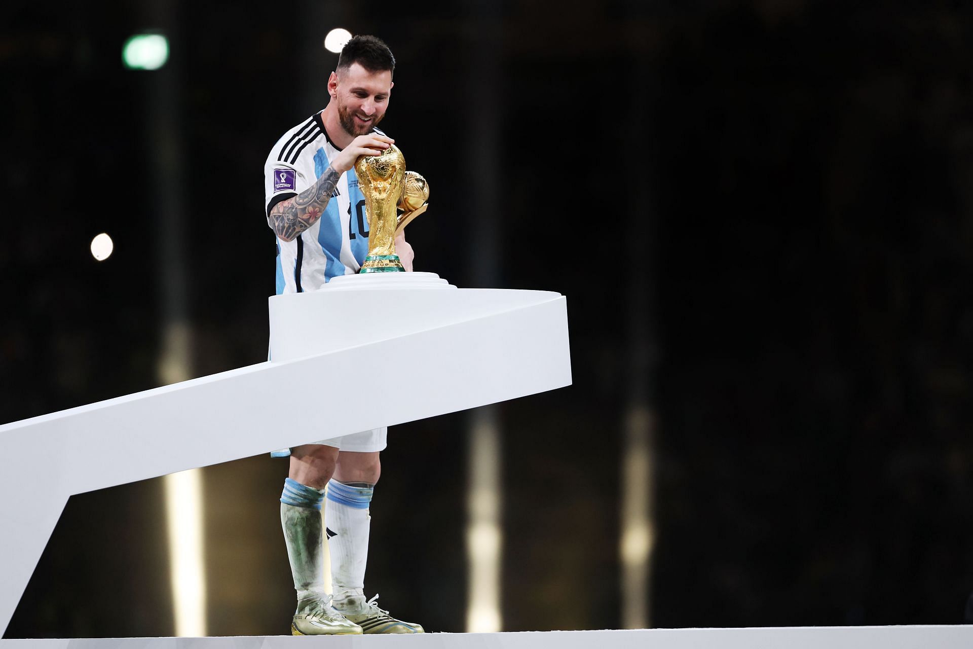 Lionel Messi embraces the World Cup trophy following their win.