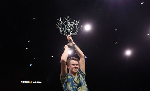 Holger Rune celebrates with the winner's trophy after defeating Novak Djokovic at the Rolex Paris Masters