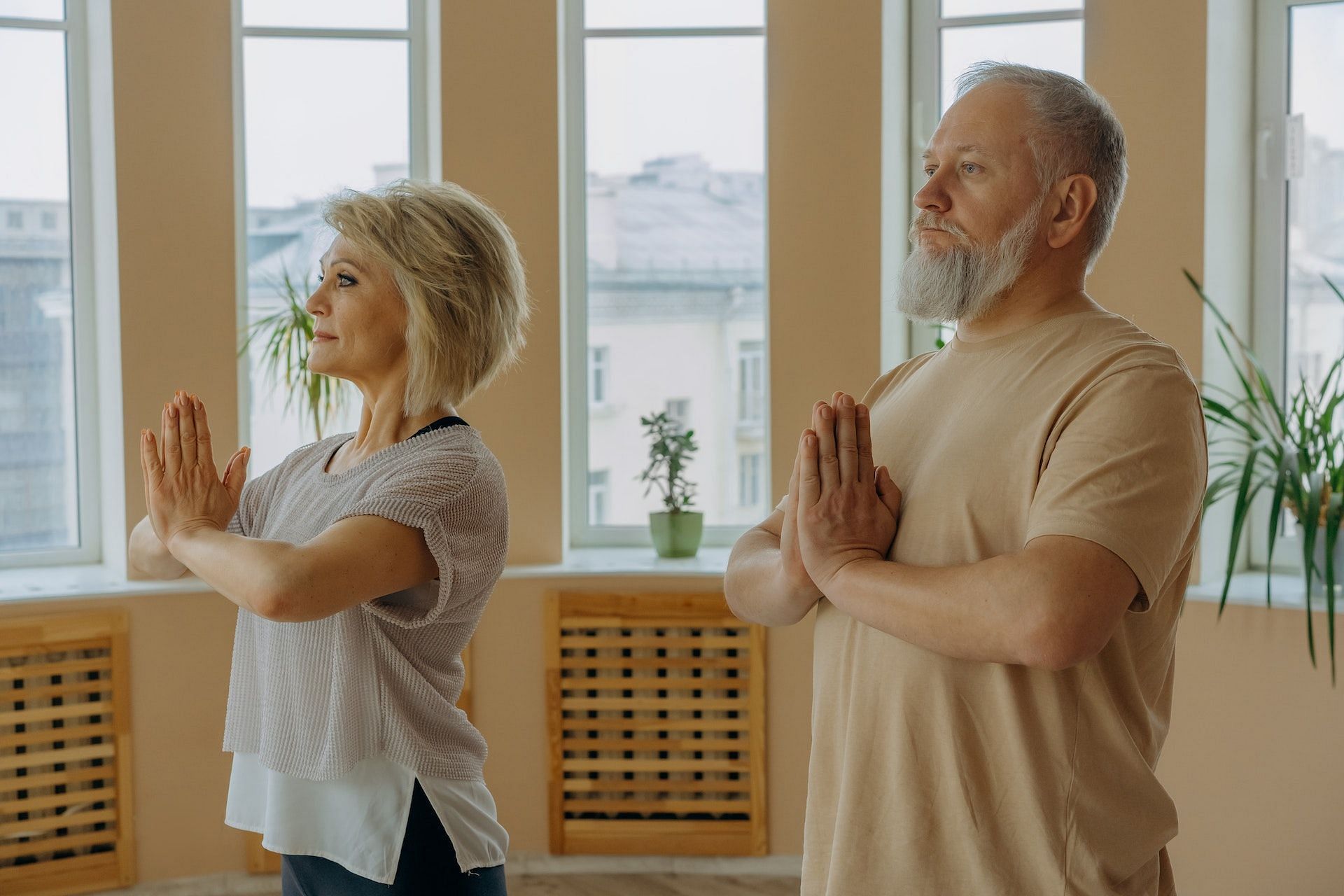 The prayer stretch eases wrist pain. (Photo via Pexels/Mikhail Nilov)