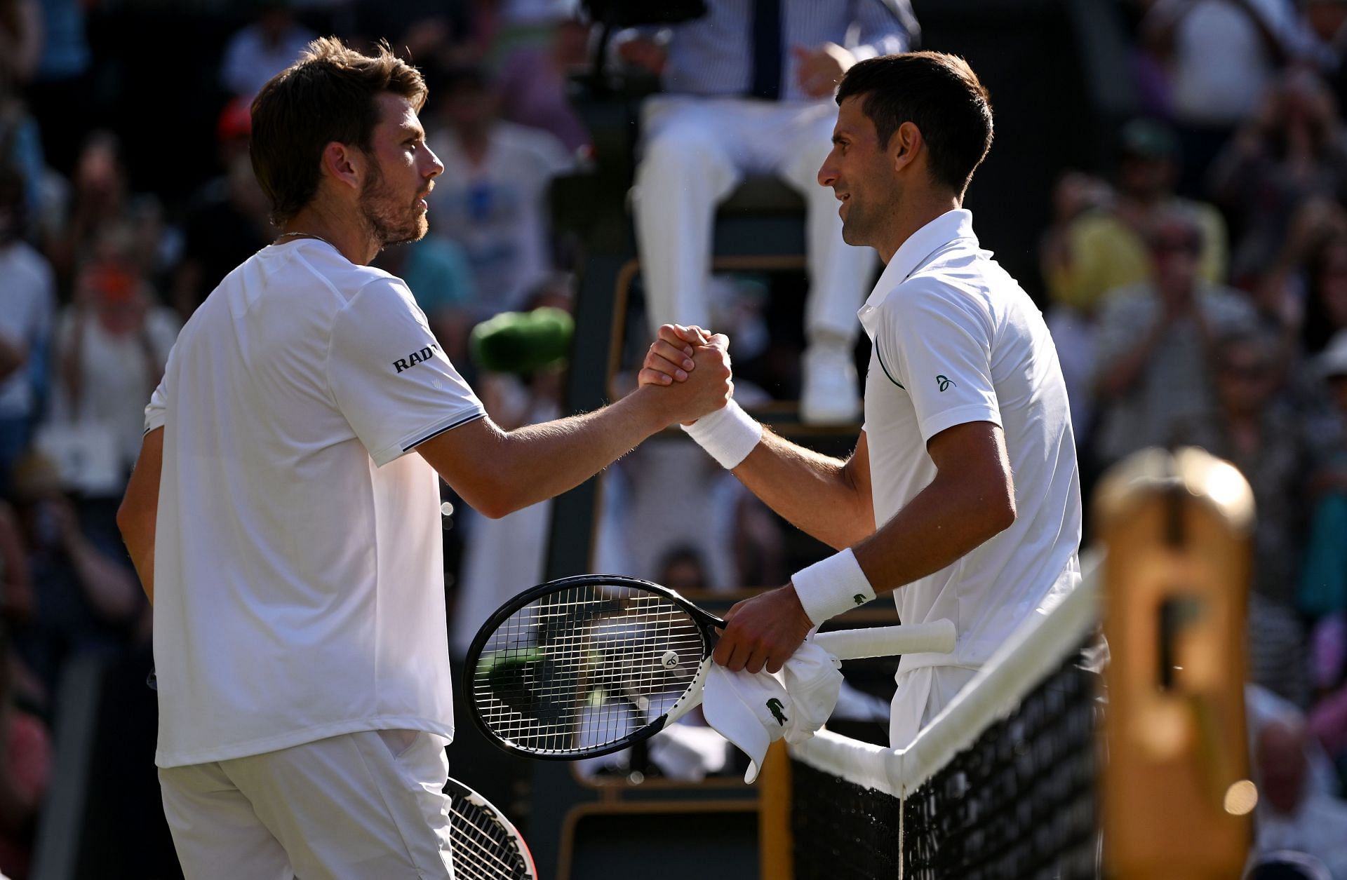Cameron Norrie (left) shakes the hand of winner Novak Djokovic (right) at the end of their semifinal match at Wimbledon last July.