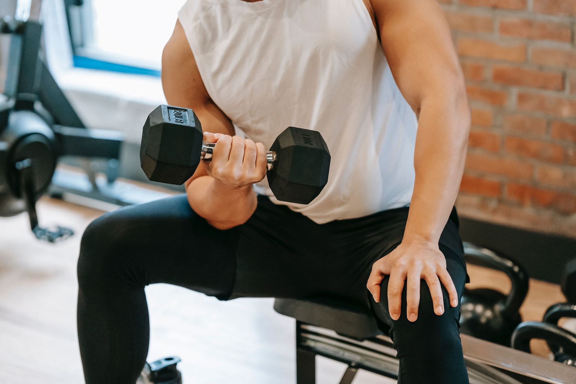 Dumbbell exercises to reduce man boobs. (Image via Pexels/Andres Ayrton)