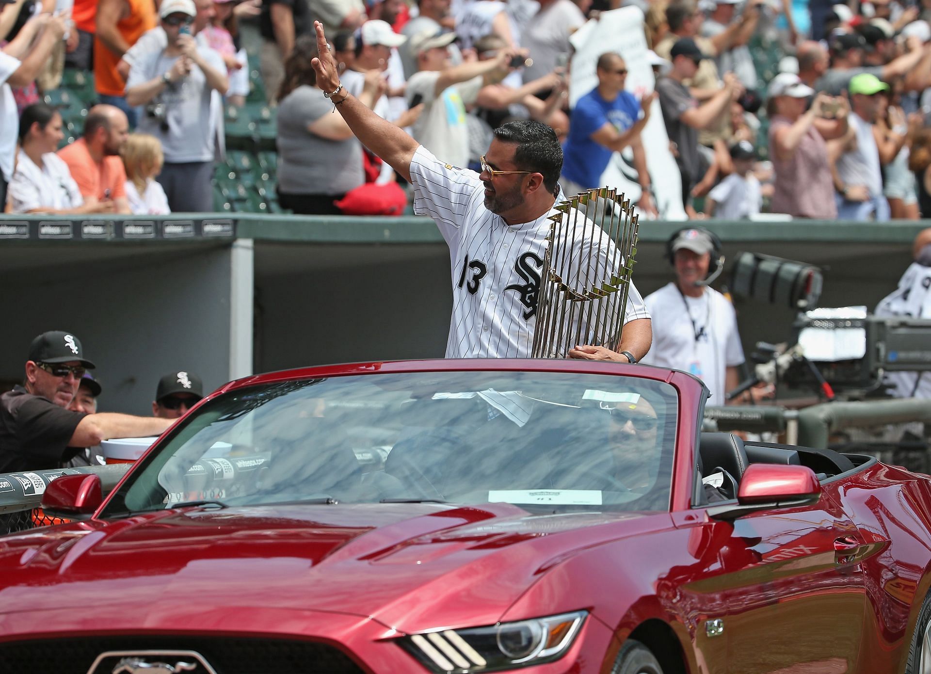 Former manager Ozzie Gullien of the Chicago White Sox greets the crowd as he rides in with the World Series trophy for a ceremony honoring the 10th anniversary of the 2005 World Series Champion Chicago White Sox team before a game against the Kansas City Royals at U.S. Cellular Field on July 18, 2015 in Chicago, Illinois.