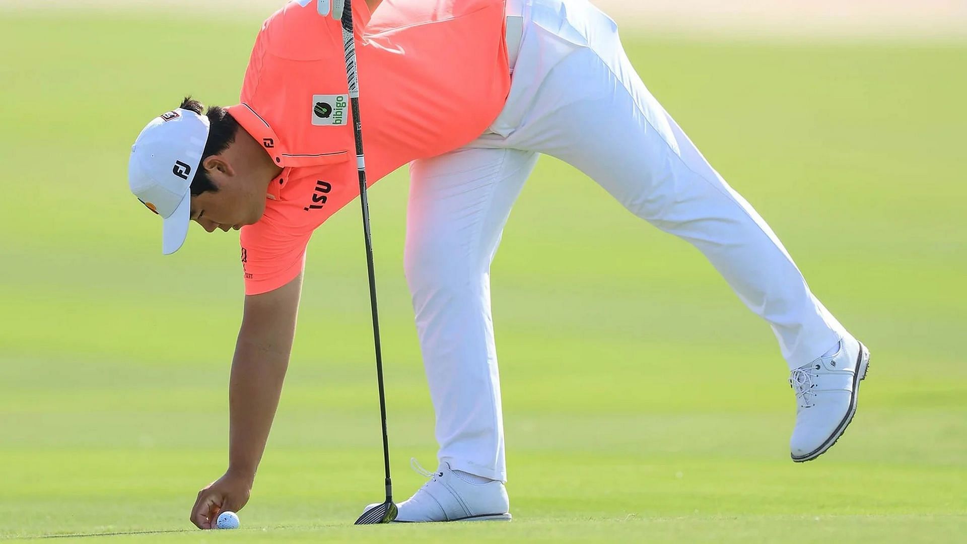 Tom Kim identifying his ball (Image via Getty)