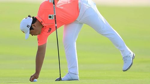 Tom Kim identifying his ball (Image via Getty)