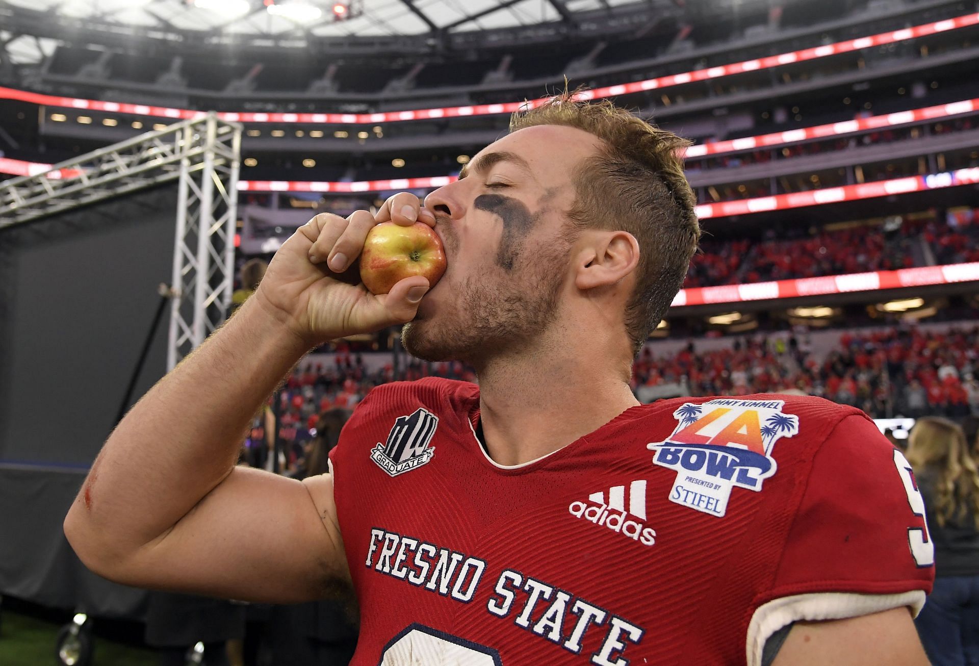 Quarterback Jake Haener of the Fresno State Bulldogs takes a bite out of an apple after defeating the Washington State Cougars
