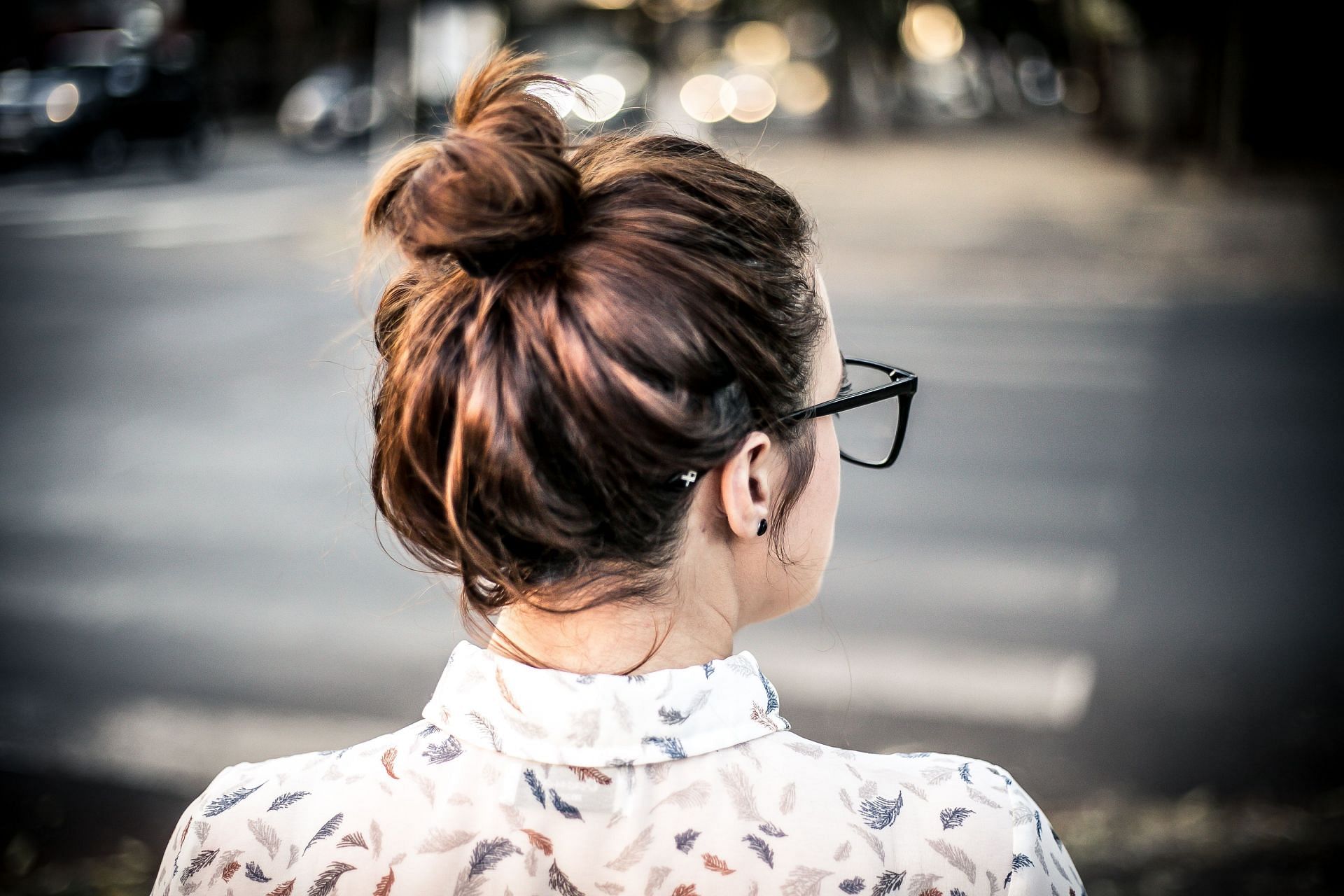 Loose hairstyles like buns are easier to fit into hair follicles (Image via Pexels/Garon Piceli)