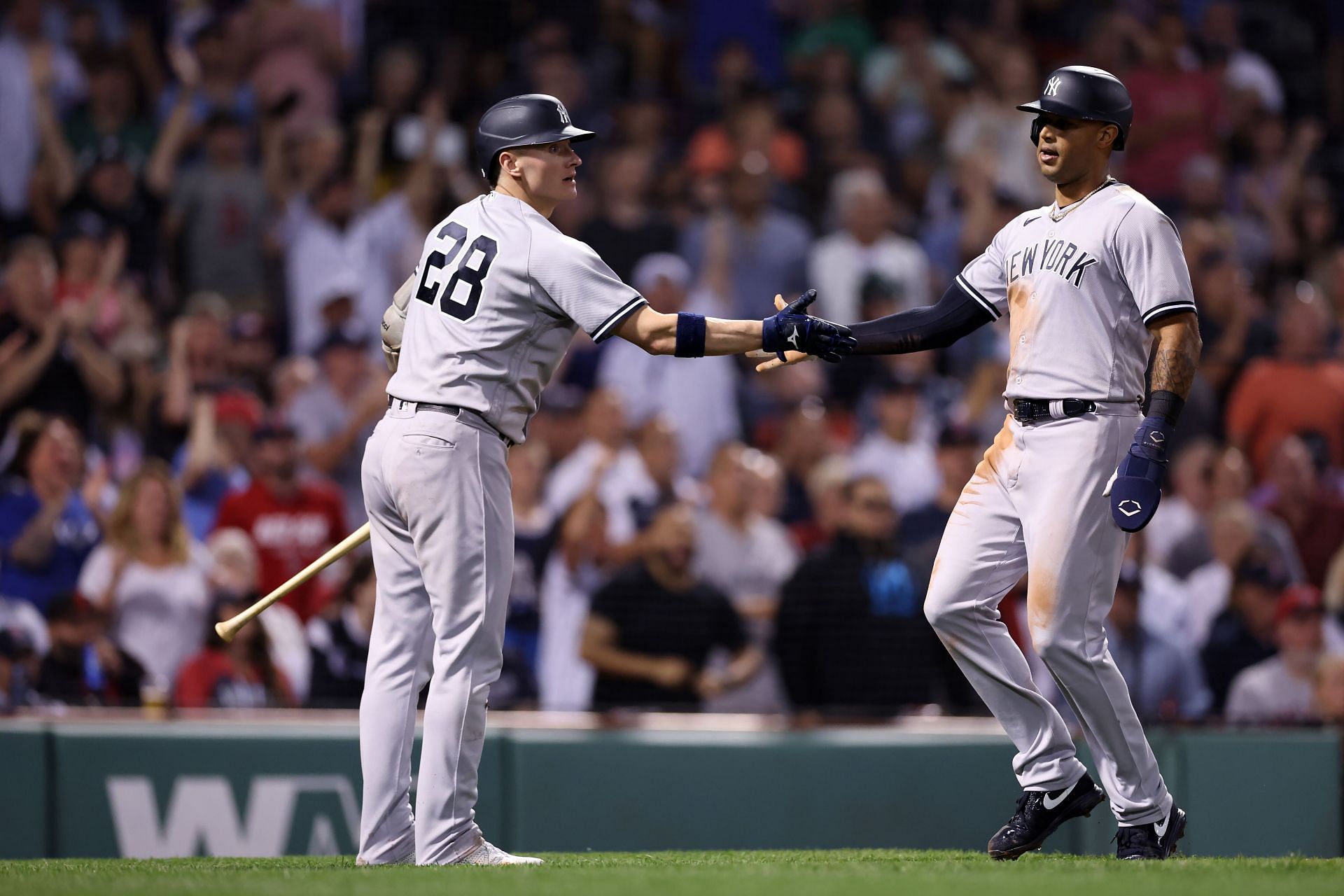 Aaron Hicks celebrates with Josh Donaldson after scoring a run at Fenway Park
